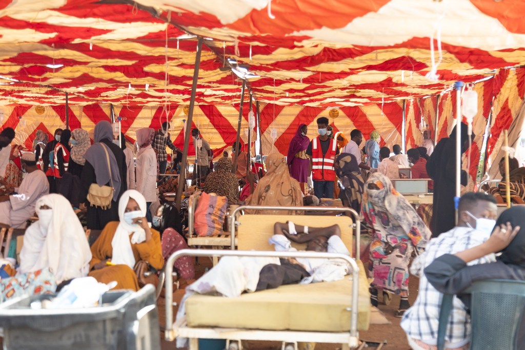 Patients receive treatment in a tent outside a hospital in Khartoum, as Sudan’s health system comes under severe strain from attacks, shortages, disease outbreaks, and natural disasters.